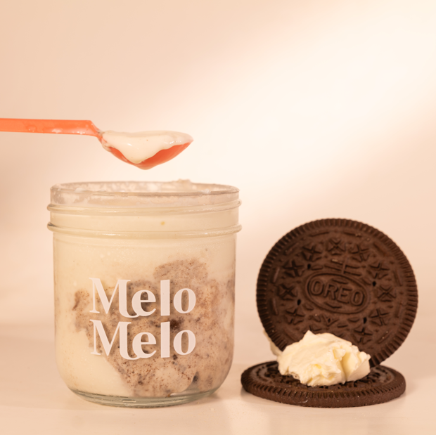 Cream Oreo coconut jelly in glass jar, creamy coconut layer with OREO® cookies and rich cream cheese  base, spoon lifting silky jelly, dripping texture, OREO  beside, clean beige background, soft natural light, premium food photography