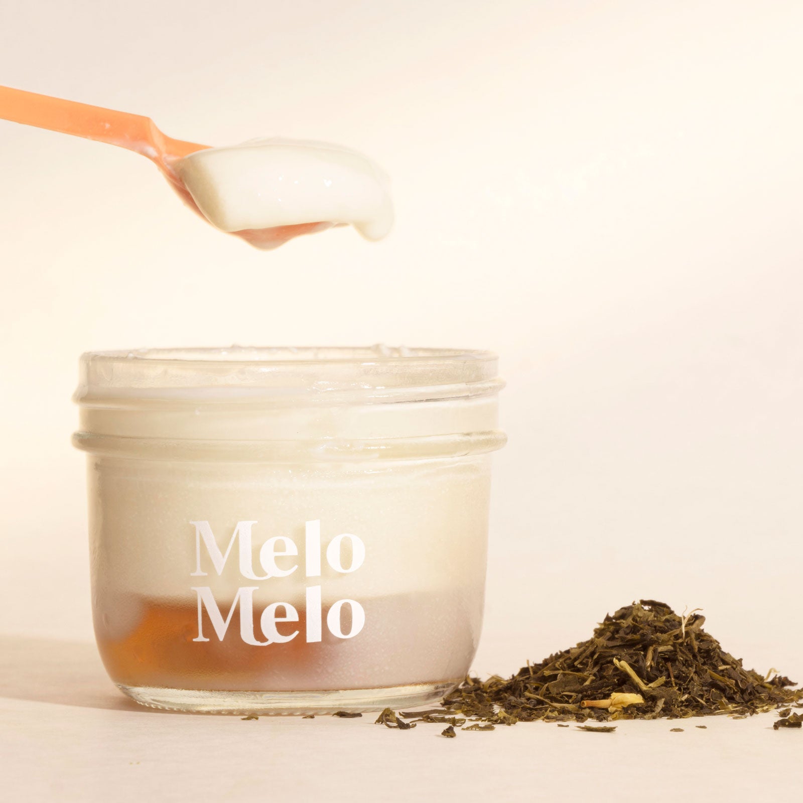 Jasmine coconut jelly in glass jar, creamy coconut layer with jasmine green tea Jelly  base, spoon lifting silky jelly, dripping texture, fresh jasmine green tea  beside, clean beige background, soft natural light, premium food photography