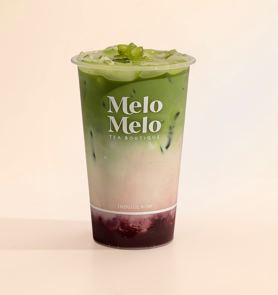 Layered matcha latte with rose grape syrup and crystal boba, creamy milk, and vibrant green matcha in a Melo Melo cup.