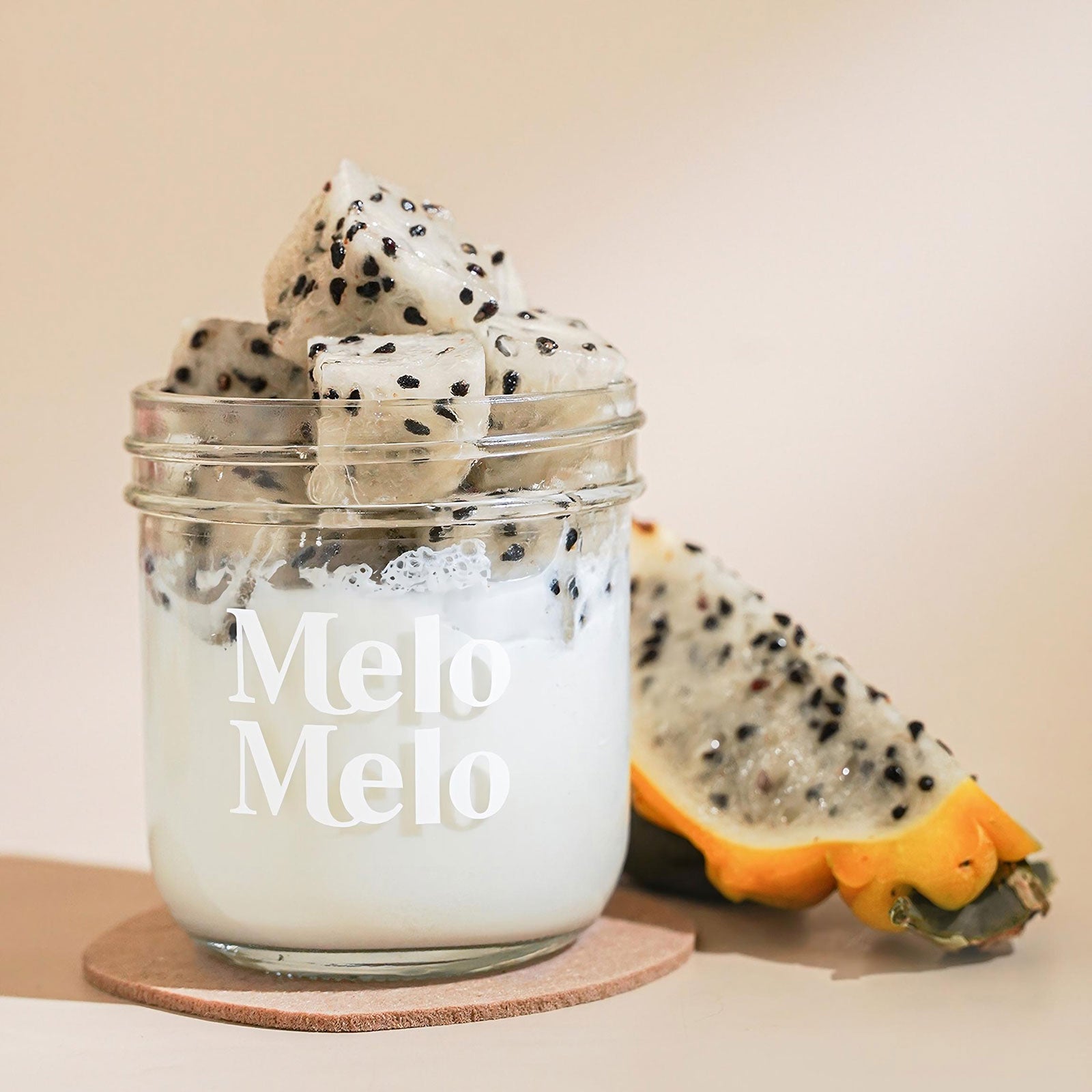 Yellow Dragon Fruit coconut jelly in a glass jar topped with vibrant fruit chunks, show casing a smooth white coconut base and vivid Yellow Dragon Fruit pieces, fresh and visually striking tropical dessert.