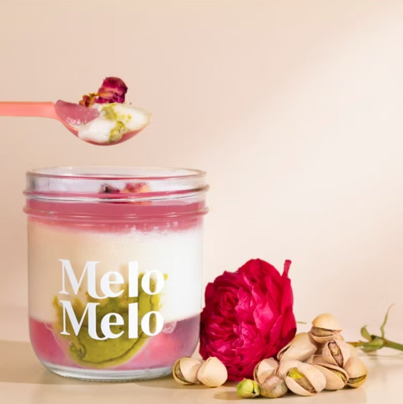 Pistachio Rose coconut jelly in glass jar, creamy coconut layer with pistachio paste, rose, and mochi., dripping texture, rose and pistachio beside, clean beige background, soft natural light, premium food photography