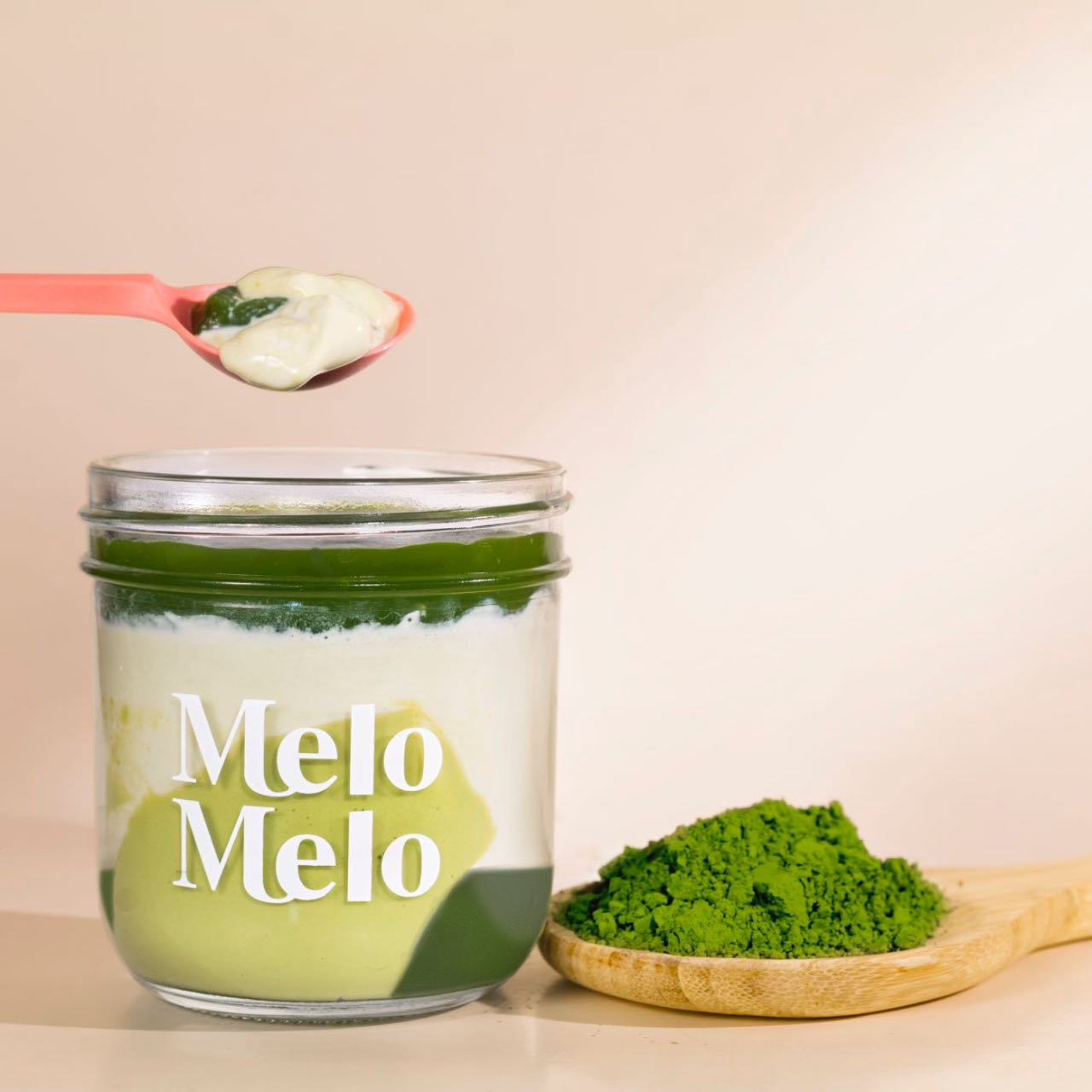 Triple Matcha coconut jelly in glass jar, creamy coconut layer with Triple Matcha jelly  base, spoon lifting silky jelly, dripping texture, fresh Triple Matcha beside, clean beige background, soft natural light, premium food photography